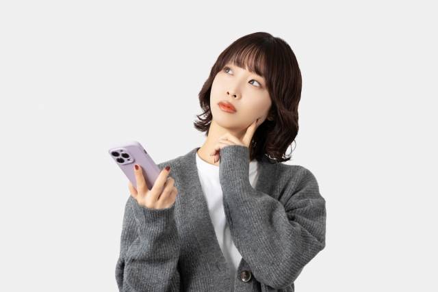 スマホを見て考える女性