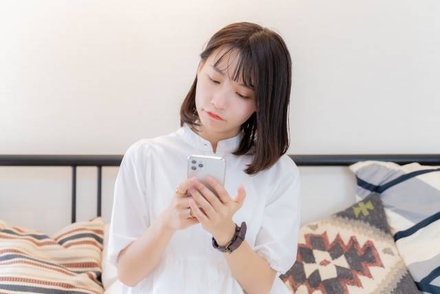 スマホを手に持つ女性