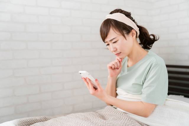 スマホのトラブルで悩んでいる女性