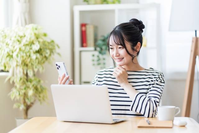 パソコンとスマホを見ている女性