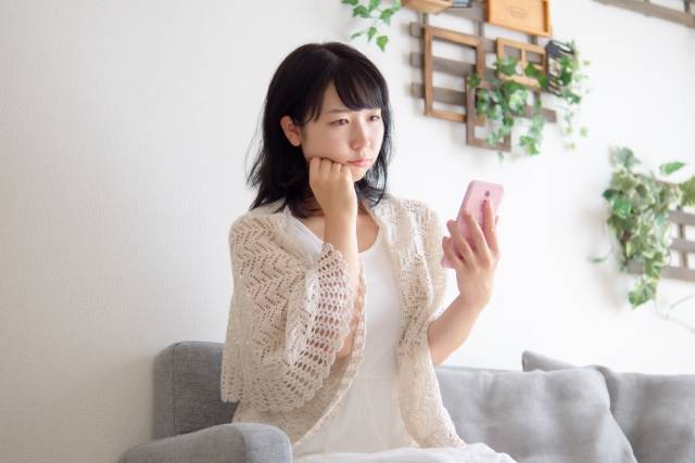 スマホ画面を見て嫌がる女性