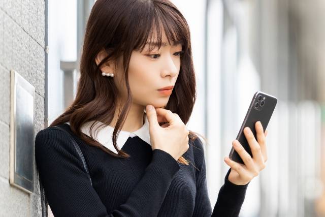 スマホ画面を見る女性