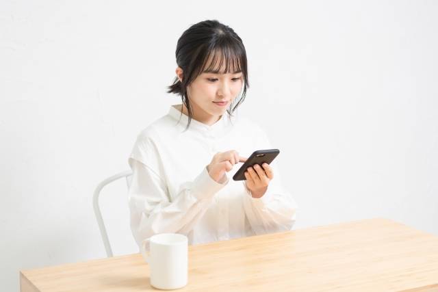 スマホで動画を見る女性