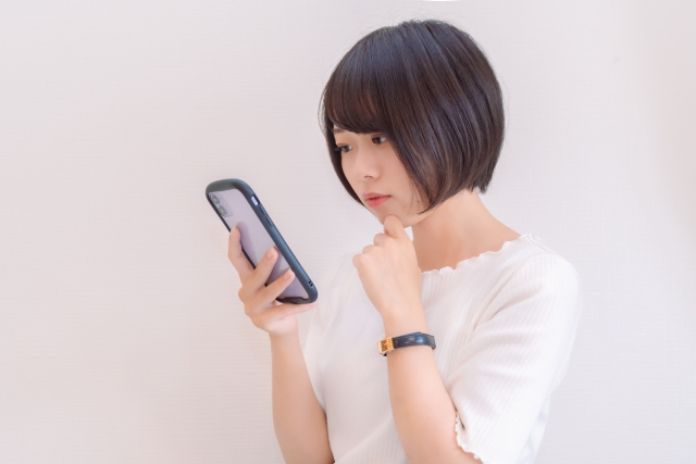 スマホを見て考える女性