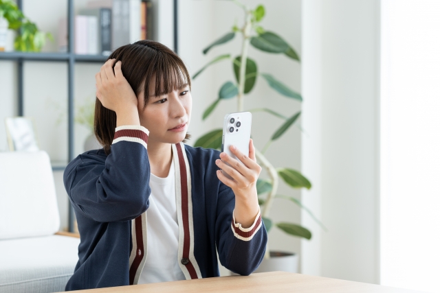 スマホを見て驚く女性