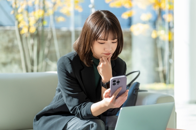 スマホを見て考える女性