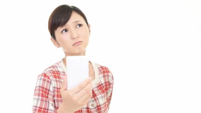 スマホを見て不安に感じている女性